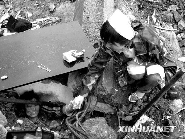 2008年5月13日，北川，一位护士不停地与一位被困孩子说话，鼓励他坚强活下去，等待救援。