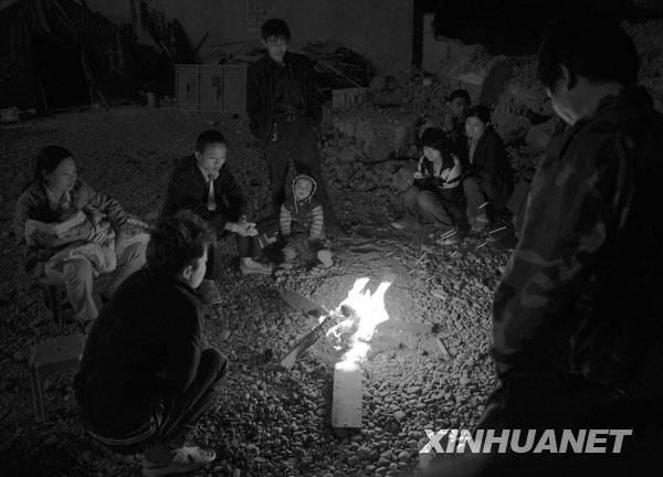 2008年5月13日凌晨，几位陇南受灾群众在烤火取暖。