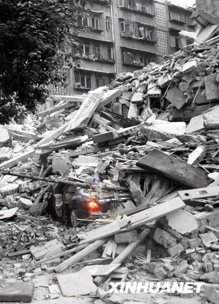 2008年5月12日，成都都江堰市一辆被埋在垮塌废墟里的汽车车灯仍在闪烁（经技术处理）。