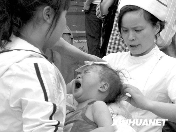 2008年5月12日14时43分，医务人员在都江堰市人民医院门前救护受伤的婴儿。