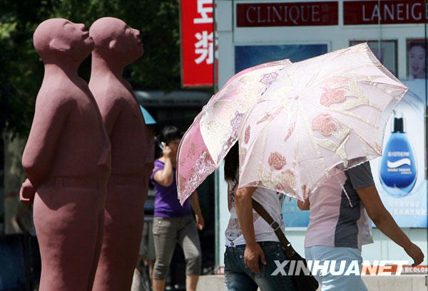 6月24日，市民撑伞走过洛阳街头。
