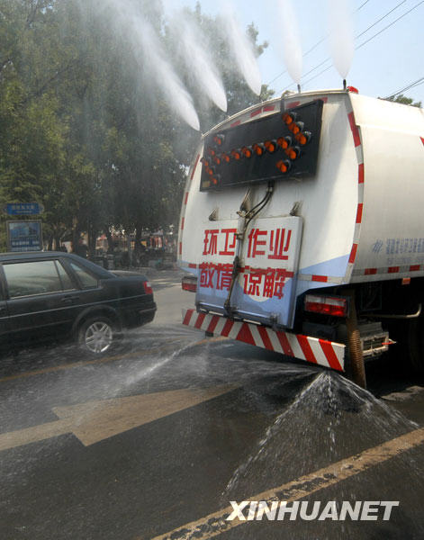 6月24日，在河北省邢台市街头，环卫洒水车上路作业，给道路洒水降温。